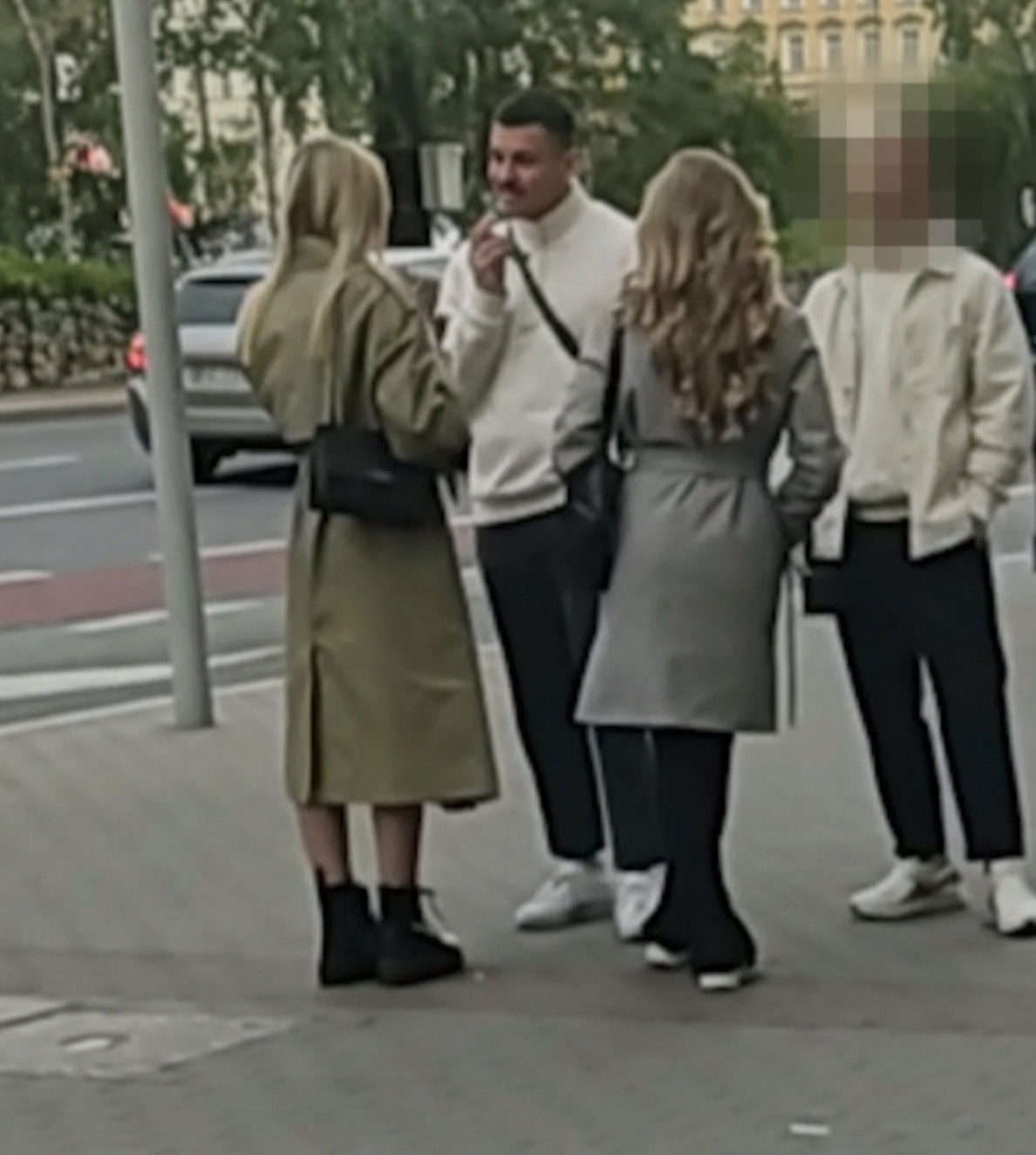 Allan en conversation avec deux femmes dans les rues de Varsovie en 2022, accompagné d'un ami dont toute la tête est fortement anonymisée
